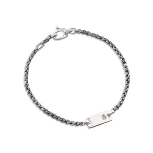 Bracciale in titanio con piastrina
e moschettone in oro bianco
con incisione femminuccia